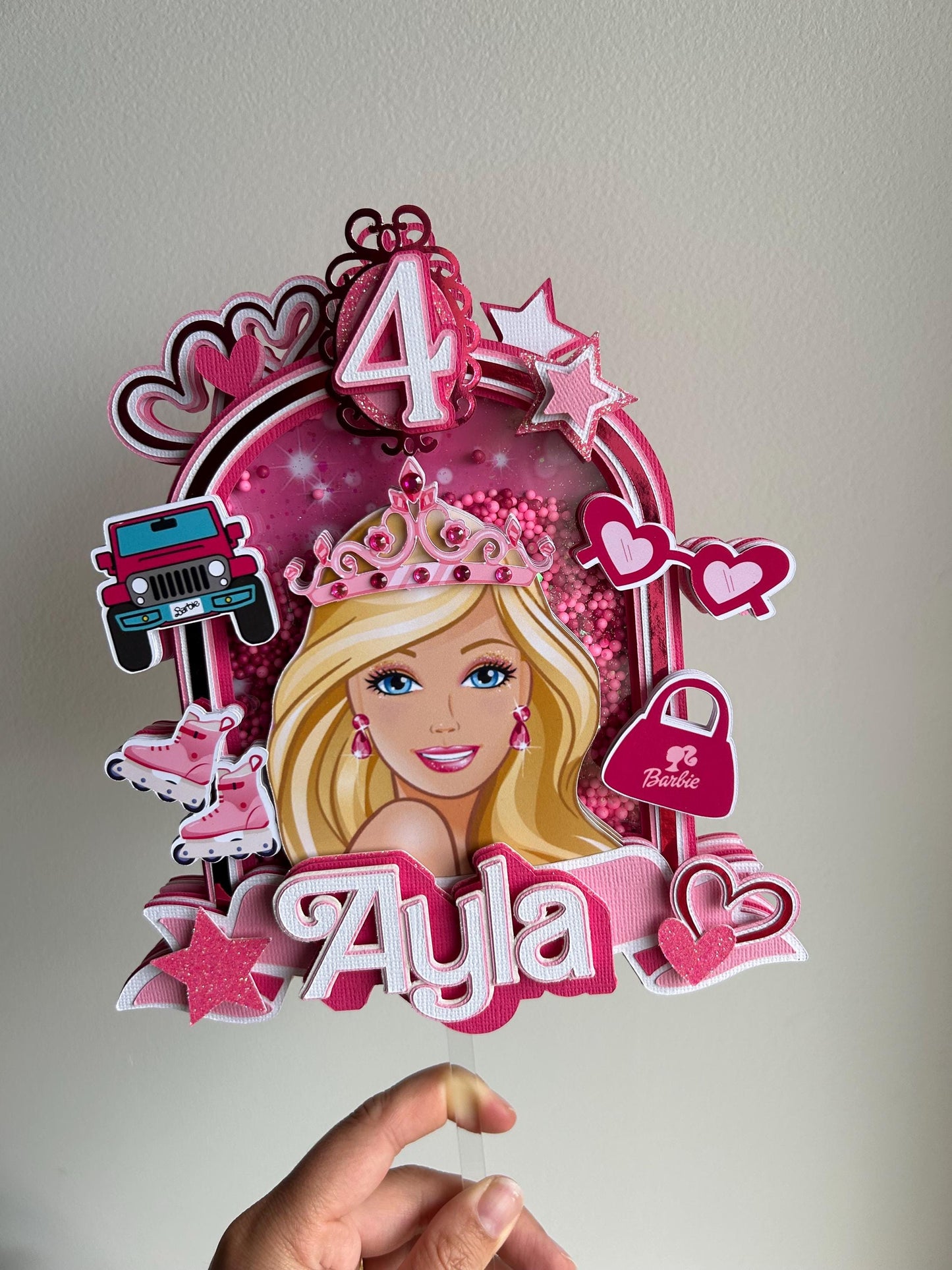 Decorative cake topper with a princess design and the name 'Ayla' on a plain background